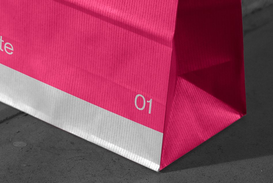 Bright pink folded paper with white stripe, numbered 01, casting sharp shadows